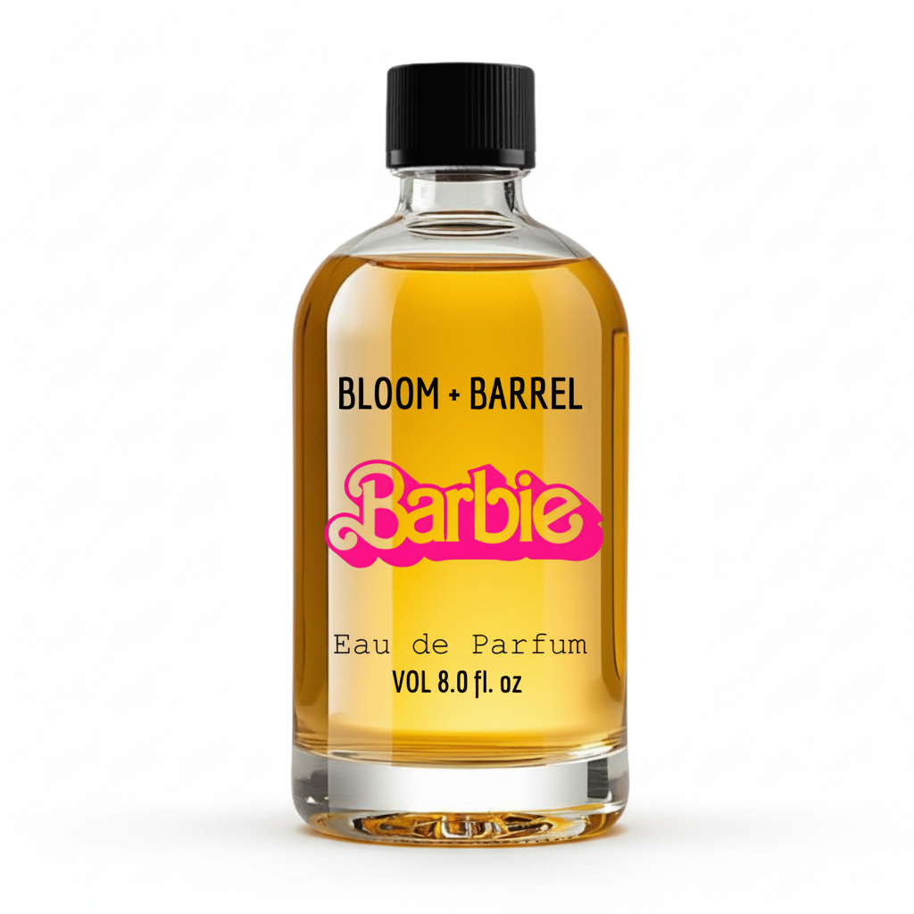 A clear glass bottle of Bloom + Barrel x Barbie Eau de Parfum with golden-yellow liquid, a black cap, and a pink Barbie logo on a white background.