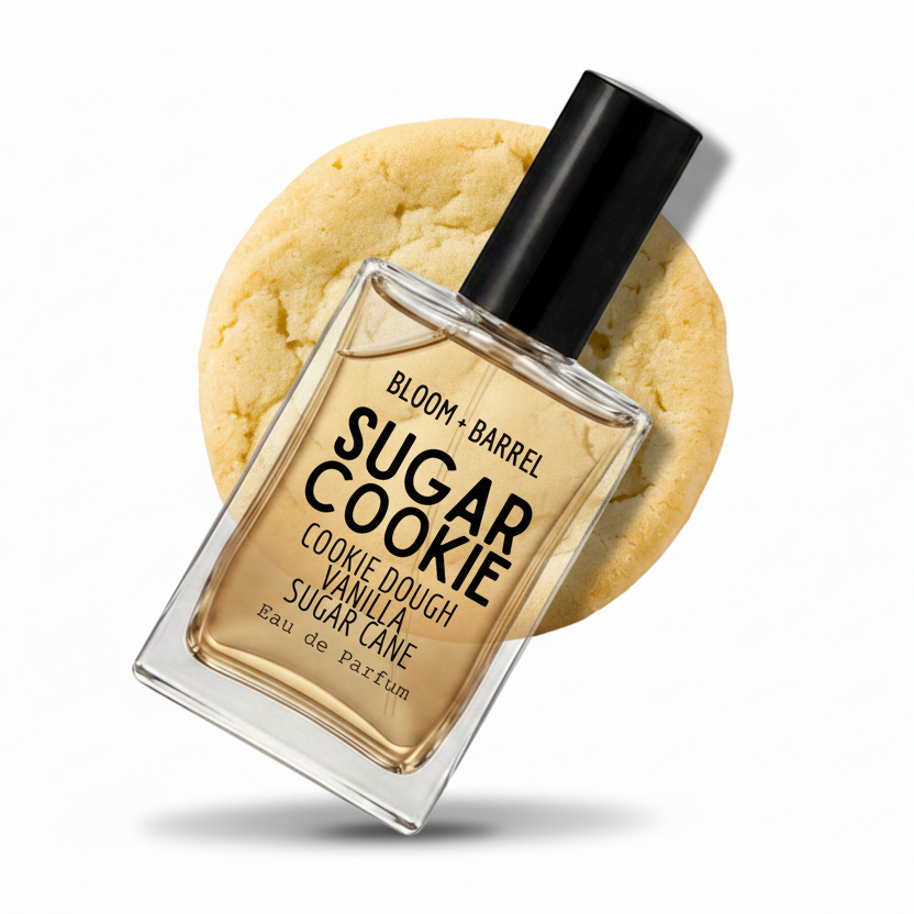 A bottle of Bloom + Barrel Sugar Cookie Eau de Parfum centered in front of a large sugar cookie graphic on a white background.