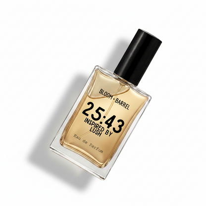 A rectangular glass perfume bottle with a black cap, filled with amber-colored fragrance liquid. The front label reads 'BLOOM • BARREL', '25:43', 'INSPIRED BY LUSH', and 'Eau de Parfum' in black text on a clean white background.