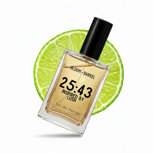 A rectangular glass perfume bottle with a black cap, filled with amber-toned fragrance, centered in front of a bright lime slice on a white background. The bottle label reads 'BLOOM • BARREL', '25:43', 'INSPIRED BY LUSH', and 'Eau de Parfum'.