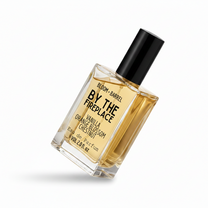 Perfume bottle labeled 'by the fireplace' by Bloom & Barrel on a white background