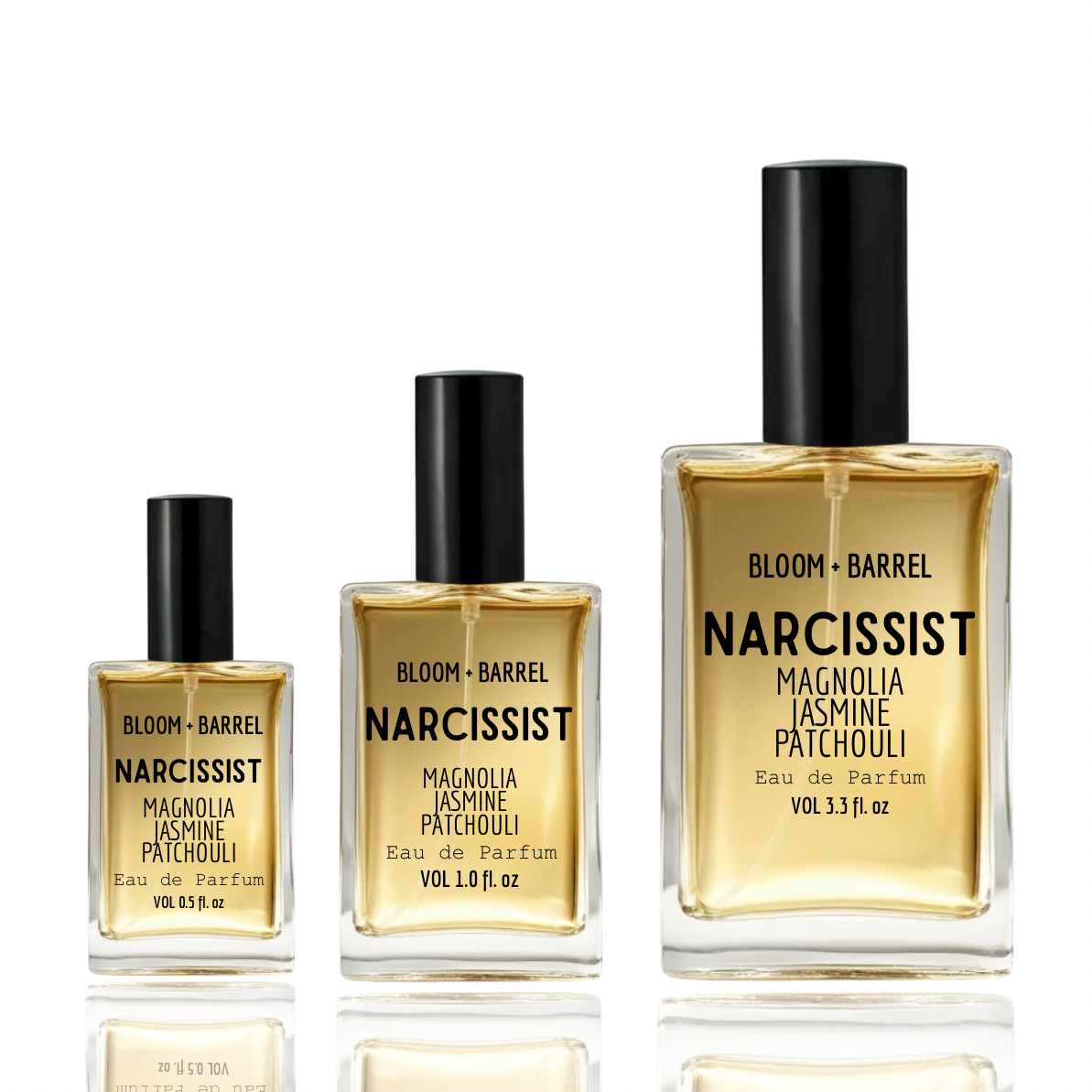 Three Bloom + Barrel Narcissist Eau de Parfum bottles in graduated sizes on a white background with reflections. The bottles are clear glass containing a golden-amber liquid, with black caps and black text on the front labels.