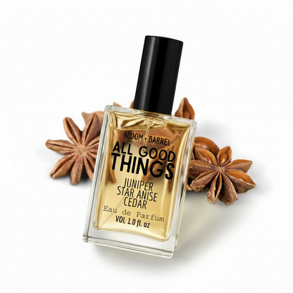 Perfume bottle labeled 'All Good Things' with star anise and juniper berries on a white background