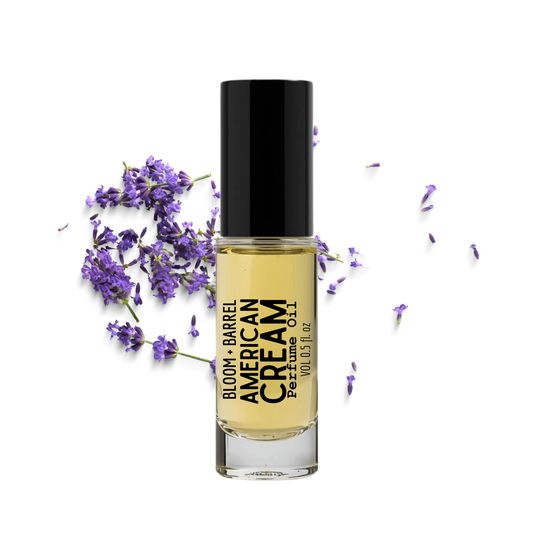 Bottle of American Cream perfume with lavender flowers on a white background