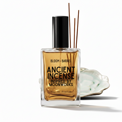 A clear glass bottle of Bloom Barrel Ancient Incense Eau de Parfum with amber-colored liquid, a black cap, and three reeds, shown with a white ceramic dish on a white background.