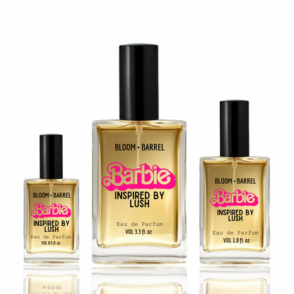 Three Barbie-inspired perfume bottles in different sizes on a white background with reflections. The center bottle is 5.