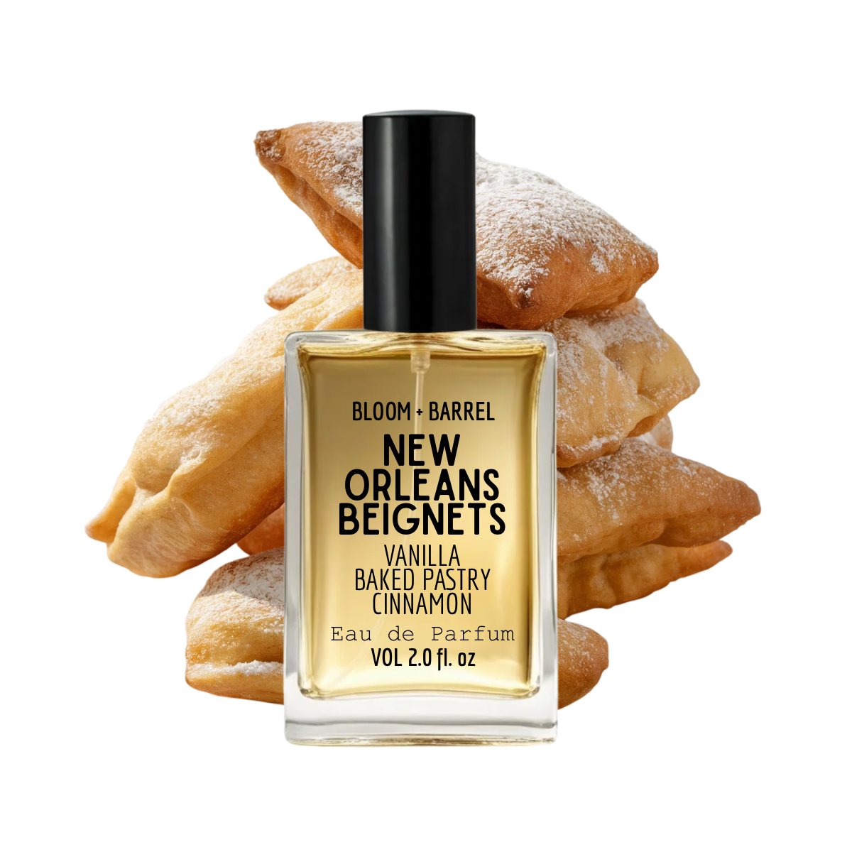 A bottle of Bloom + Barrel New Orleans Beignets Eau de Parfum centered in front of a stack of baked beignets on a plain white background.