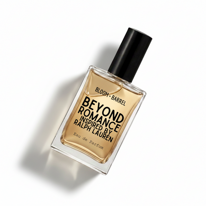A rectangular glass bottle of Bloom Barrel Beyond Romance Eau de Parfum with a black cap, filled with amber-colored liquid, on a solid white background.