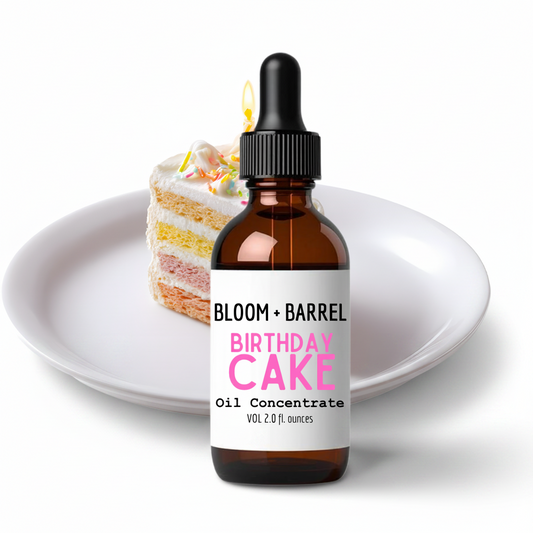 Bottle of Bloom + Barrel Birthday Cake oil concentrate with a slice of birthday cake on a white plate.