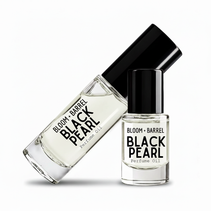 Two clear glass bottles of Bloom + Barrel black pearl perfume oil with black caps, one roll-on bottle and one perfume oil bottle, on a white background.