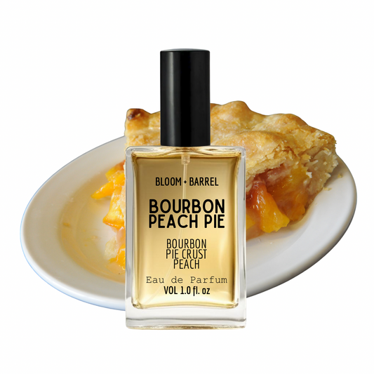 Bottle of Bloom & Barrel Bourbon Peach Pie perfume with a slice of peach pie on a white plate.