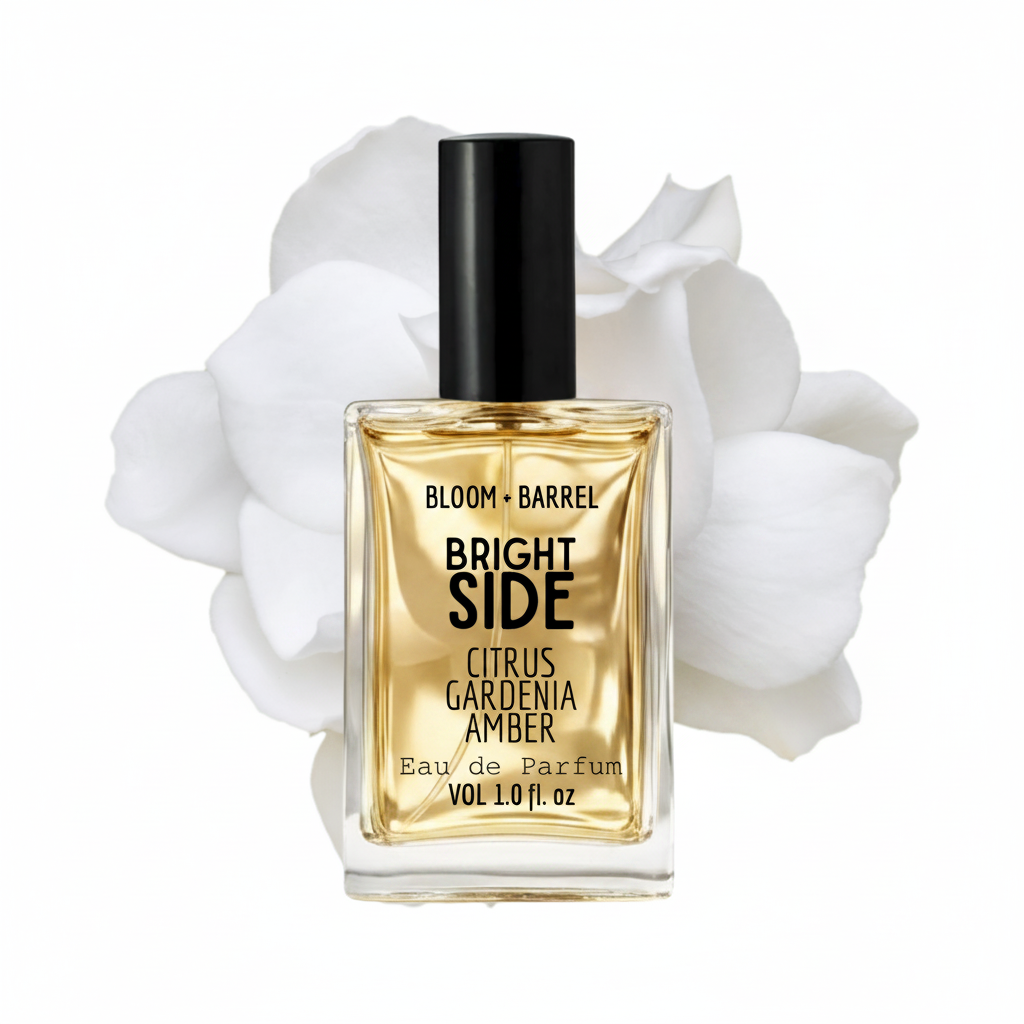 Perfume bottle labeled 'Bloom + Barrel Bright Side' with white flowers in the background