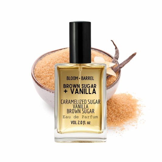 Perfume bottle labeled 'Brown Sugar + Vanilla' with a bowl of sugar and vanilla bean in the background.