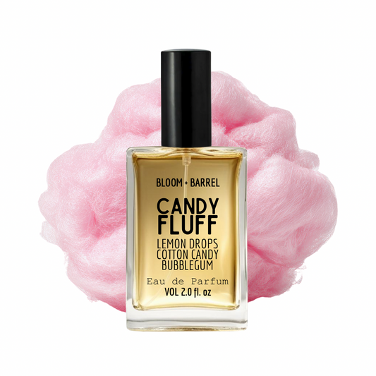 Perfume bottle labeled 'Candy Fluff' with pink cotton candy in the background