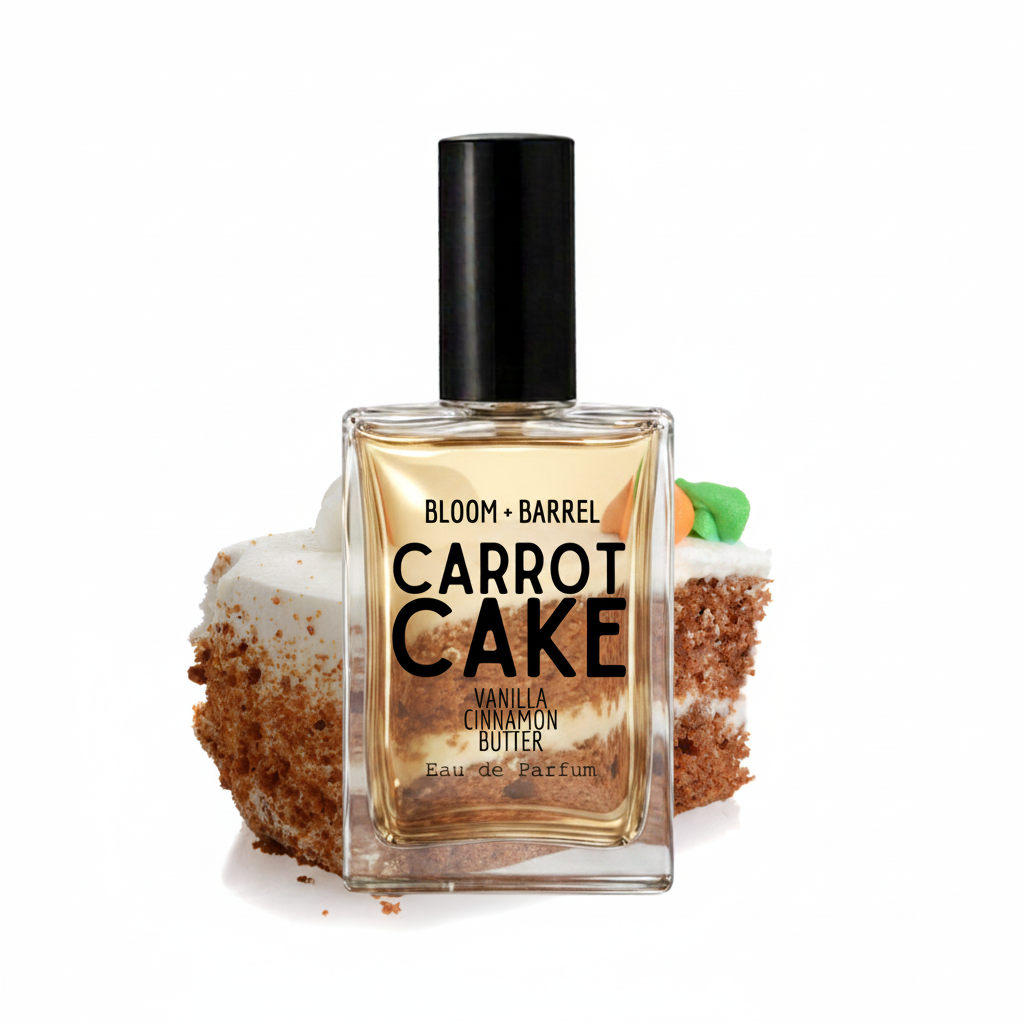 A perfume bottle labeled 'BLOOM + BARREL CARROT CAKE Vanilla Cinnamon Butter' stands centered in front of a sliced carrot cake on a white background.