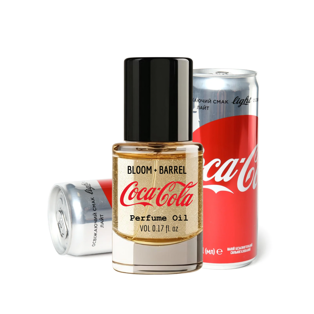 Bloom Barrel Coca-Cola perfume oil bottle with two cans of Coca-Cola on a white background