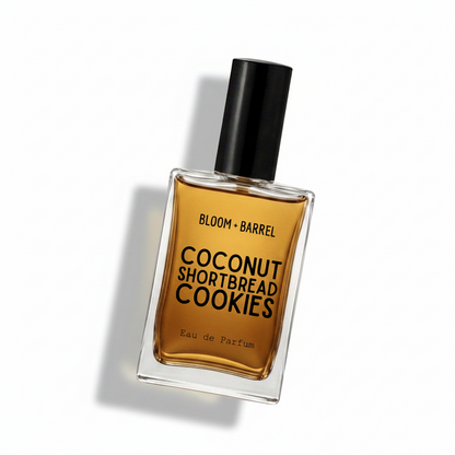 A rectangular glass perfume bottle with amber-brown liquid, a black cap, and bold black text reading 'BLOOM • BARREL' and 'COCONUT SHORTBREAD COOKIES' on a white background.