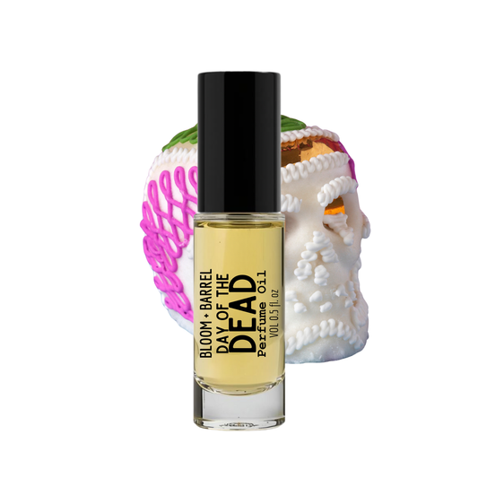 Perfume bottle labeled 'Day of the Dead' with decorative skull and pink object on a white background