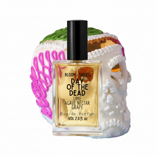 Perfume bottle with decorative skull and floral elements on a white background