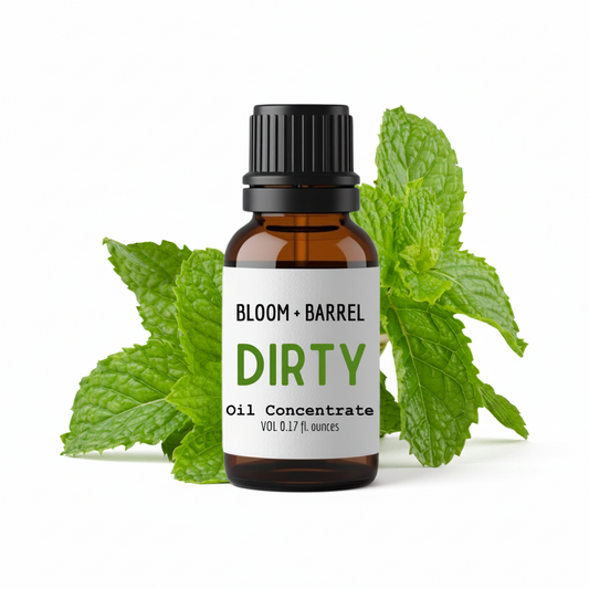 Bottle of Bloom & Barrel Dirty Oil Concentrate with mint leaves on a white background