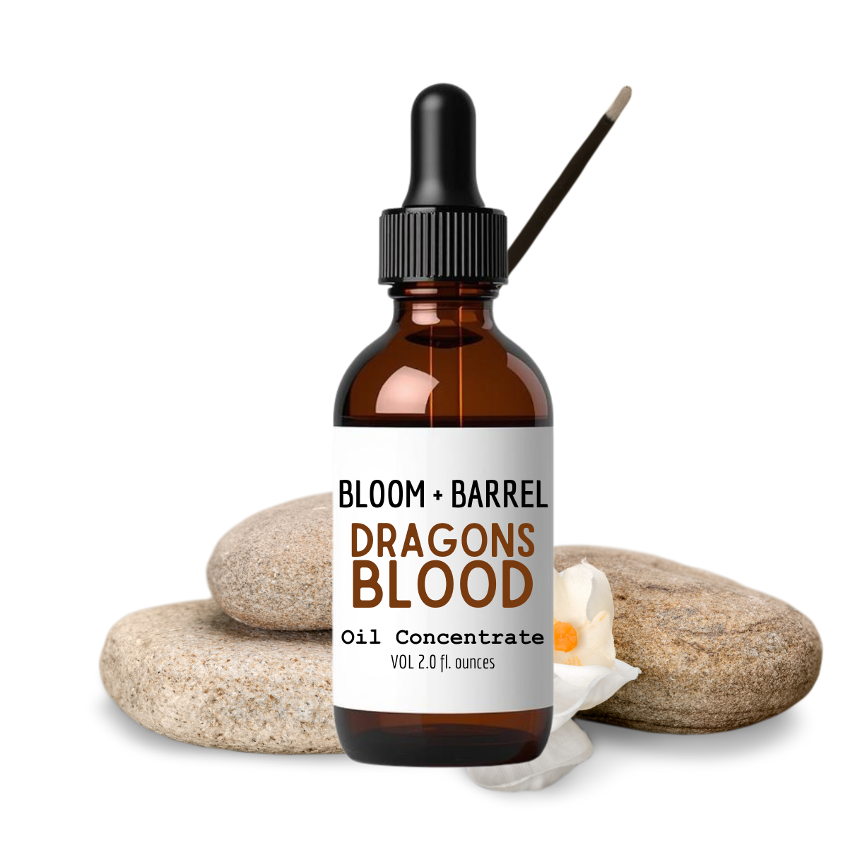 Bottle of Bloom + Barrel Dragons Blood Oil Concentrate with stones and a candle on a white background