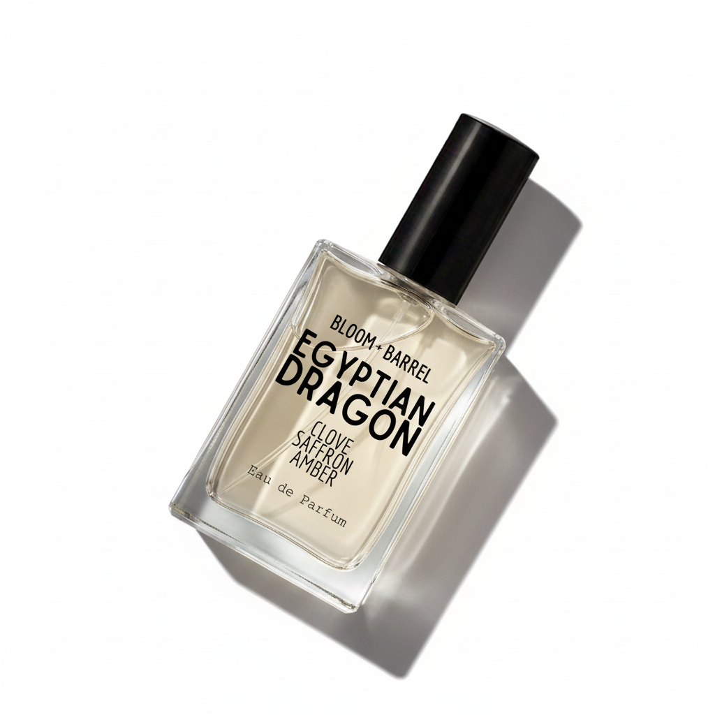 A rectangular glass perfume bottle with a black cap, labeled 'BLOOM • BARREL EGYPTIAN DRAGON CLOVE SAFFRON AMBER Eau de Parfum', centered on a plain white background.