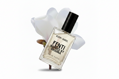 A clear rectangular perfume bottle with a black cap, labeled 'BLOOM • BARREL' and 'FENTI INSPIRED BY RIHANNA', centered against a white background with soft white flower petals behind it.