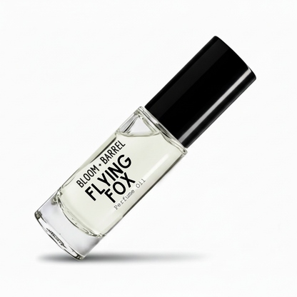 A clear glass perfume oil bottle with a black cap, labeled 'BLOOM + BARREL flying fox Perfume Oil', shown on a clean white background with a soft shadow.