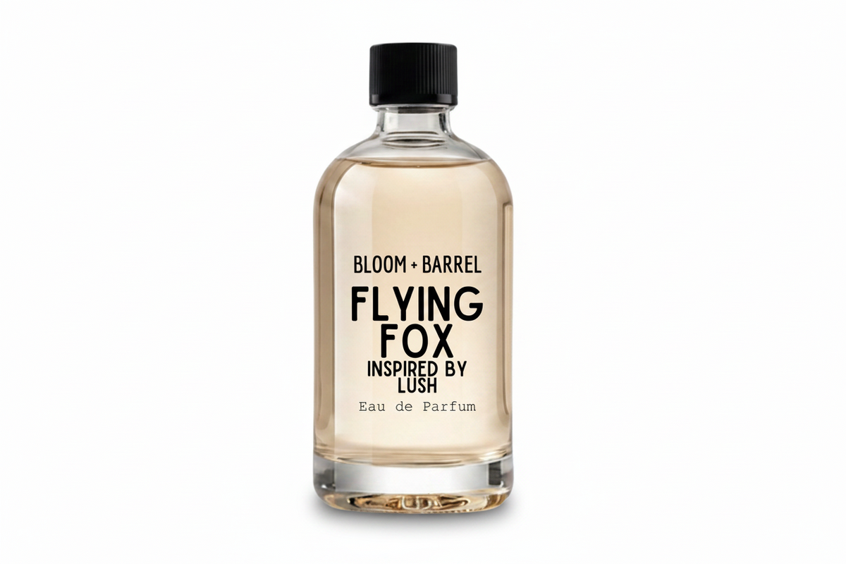 A clear glass bottle of Bloom + Barrel Flying Fox Eau de Parfum with a black cap, filled with a light amber liquid, on a solid white background.
