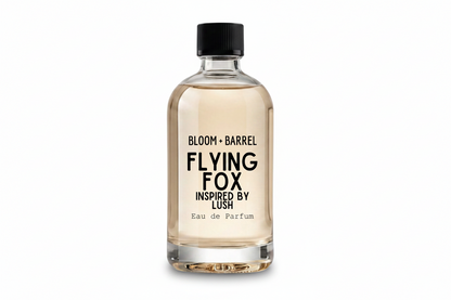 A clear glass bottle of Bloom + Barrel Flying Fox Eau de Parfum with a black cap, filled with a light amber liquid, on a solid white background.