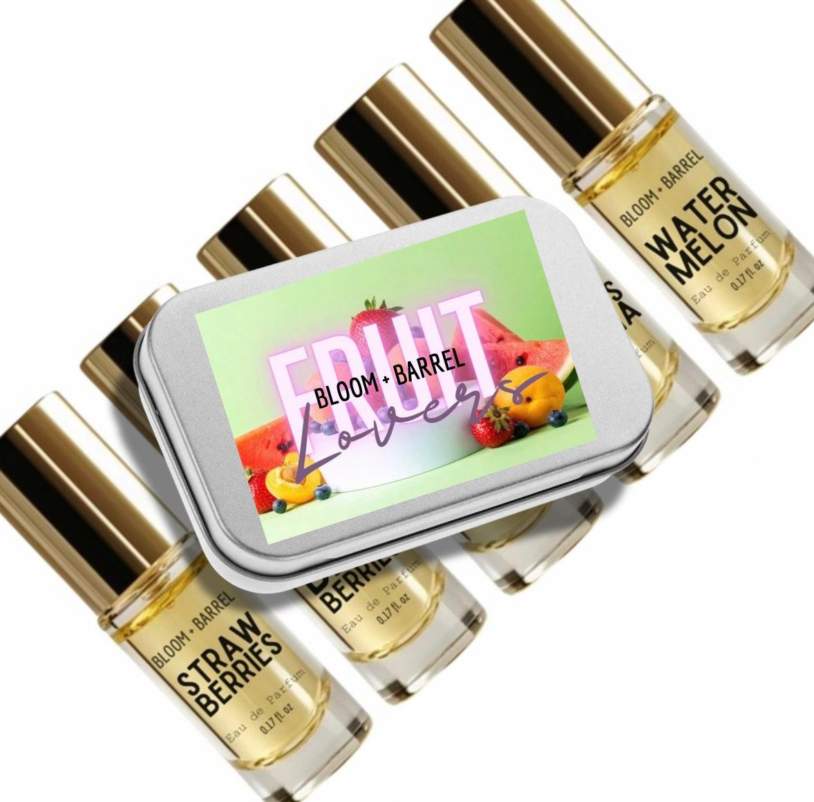 A set of six small fragrance oil bottles with gold caps arranged around a rectangular metal tin labeled 'FRUIT Love' by Bloom + Barrel. The bottles are labeled with scents including Watermelon, Strawberry, and Bergamot, and the liquid inside is pale yellow.