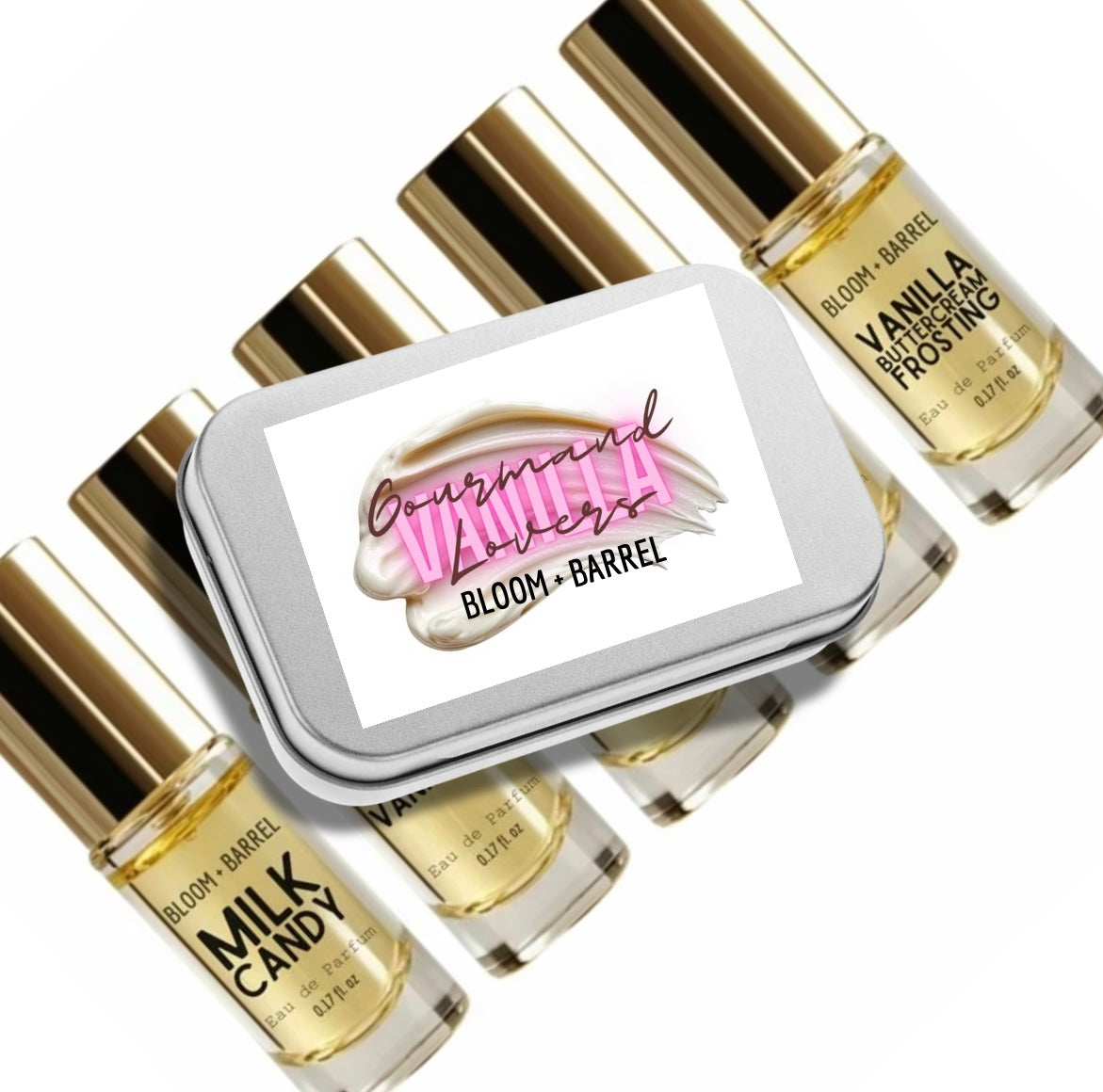 A group of Bloom + Barrel perfume or fragrance bottles with gold caps and pale yellow liquid, arranged around a central silver tin labeled 'Carnival Wreath' and 'Bloom + Barrel'. Visible bottle labels include Vanilla Blossom Frosting, Milk Candy, and a central scent name in script.
