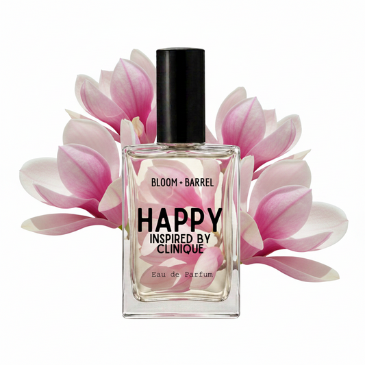 A rectangular glass perfume bottle with a black cap, labeled 'BLOOM • BARREL HAPPY INSPIRED BY CLINIQUE Eau de Parfum', centered against a white background with pink and white flower petals behind it.