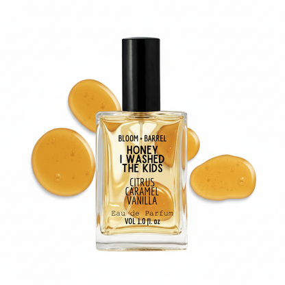 Perfume bottle labeled 'Honey I Washed the Kids' with yellow droplets on a white background