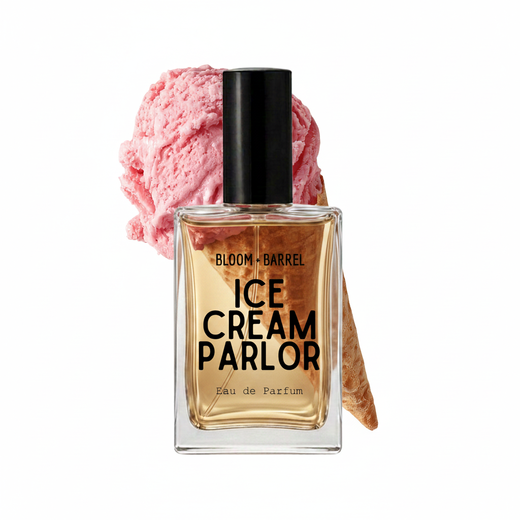 A rectangular glass perfume bottle labeled 'BLOOM • BARREL ICE CREAM PARLOR Eau de Parfum' with a black cap, shown in front of a pink ice cream scoop and waffle cone on a white background.