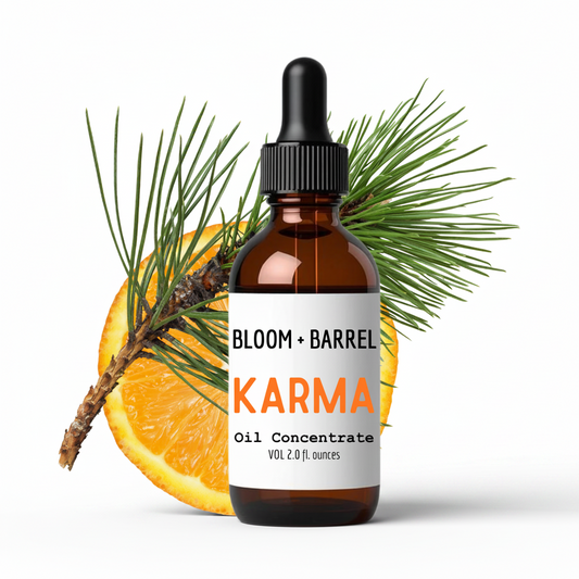Bottle of Bloom & Barrel Karma oil concentrate with an orange and pine branch on a white background