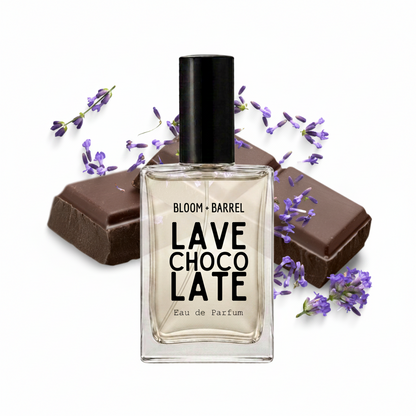 A clear glass perfume bottle labeled 'BLOOM • BARREL CHOCO LATE LAVE Eau de Parfum' with a black cap, centered on a white background and styled with chocolate bars and purple lavender sprigs.