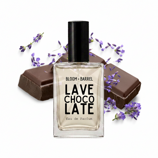 A clear glass perfume bottle labeled 'BLOOM • BARREL CHOCO LATE LAVE Eau de Parfum' with a black cap, centered on a white background and styled with chocolate bars and purple lavender sprigs.