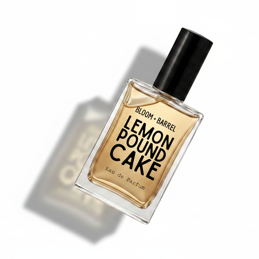 Bloom Barrel Lemon Pound Cake Eau de Parfum in a clear rectangular glass bottle with a black cap, filled with amber-colored fragrance liquid, on a plain white background.