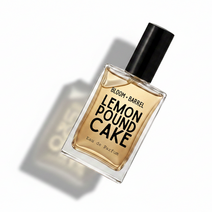 Bloom Barrel Lemon Pound Cake Eau de Parfum in a clear rectangular glass bottle with a black cap, filled with amber-colored fragrance liquid, on a plain white background.