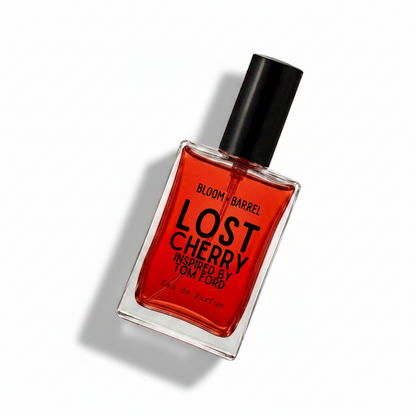 Bloom Barrel Lost Cherry Eau de Parfum in a clear rectangular glass bottle with vibrant red liquid, a black cap, and bold black text on the front, set against a plain white background.