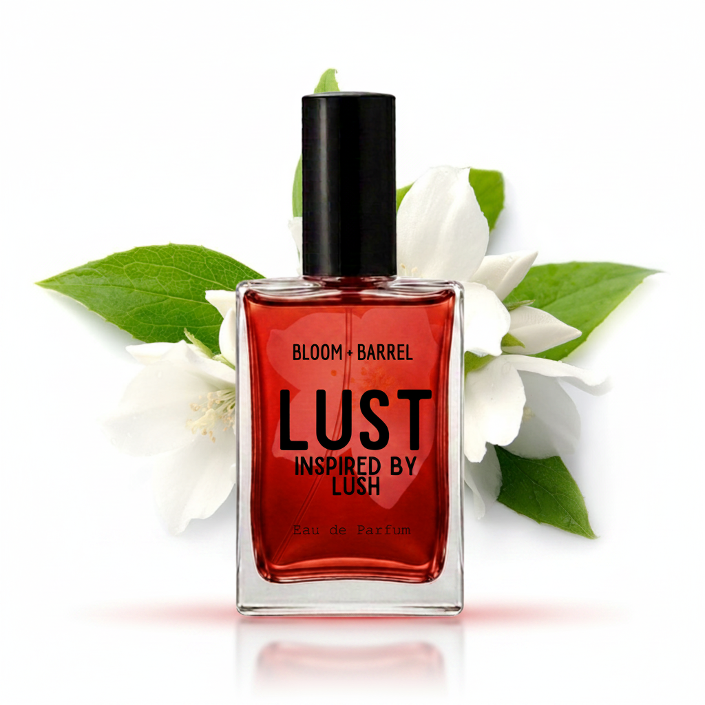 A rectangular glass perfume bottle with a black cap, filled with a deep red liquid, labeled 'BLOOM • BARREL LUST INSPIRED BY LUSH'. The bottle is styled with white blossoms and green leaves on a clean white background.