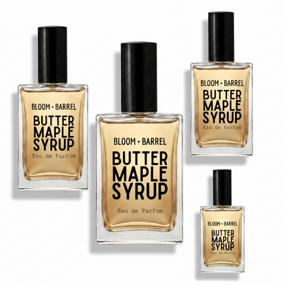 Four glass perfume bottles labeled BLOOM + BARREL Butter Maple Syrup Eau de Parfum, arranged on a plain white background. The bottles contain a warm amber liquid and have black caps.