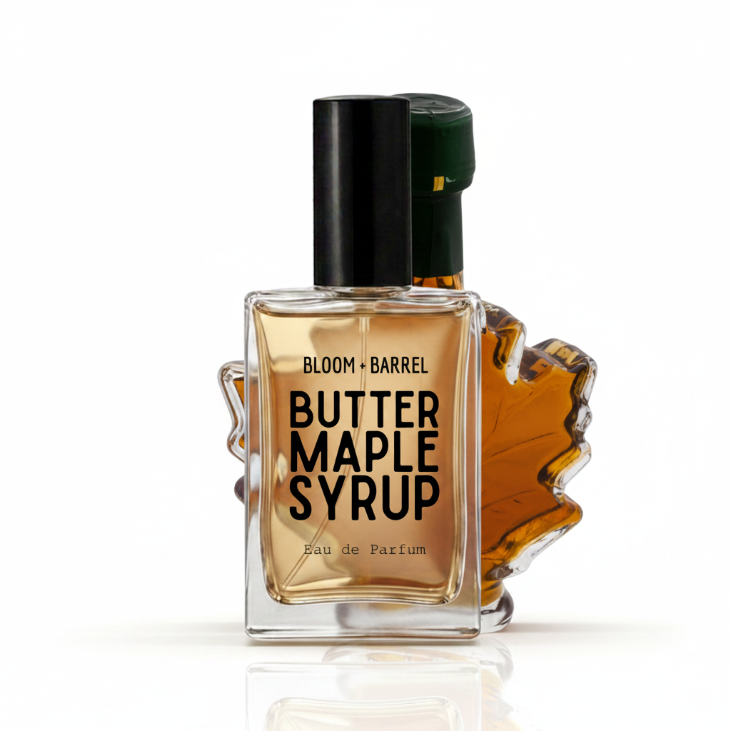 Bloom Barrel Butter Maple Syrup Eau de Parfum bottle with a clear glass body showing amber liquid, a black cap, and a maple leaf-shaped accent on a white background.
