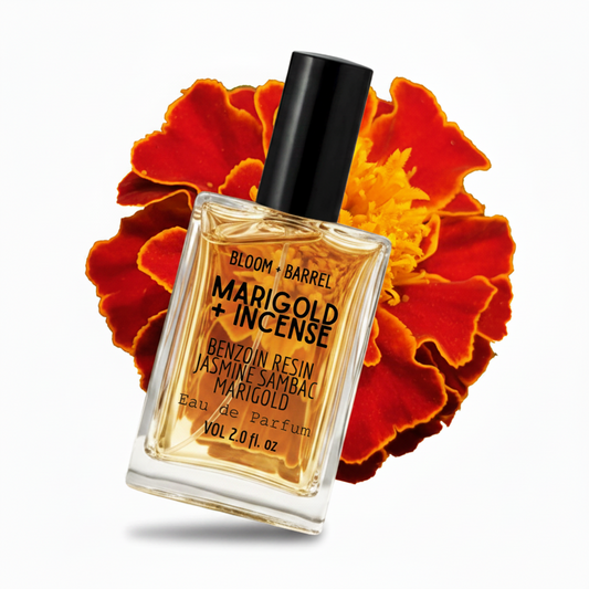 Bottle of Bloom + Barrel Marigold + Incense Eau de Parfum with marigold flowers in the background