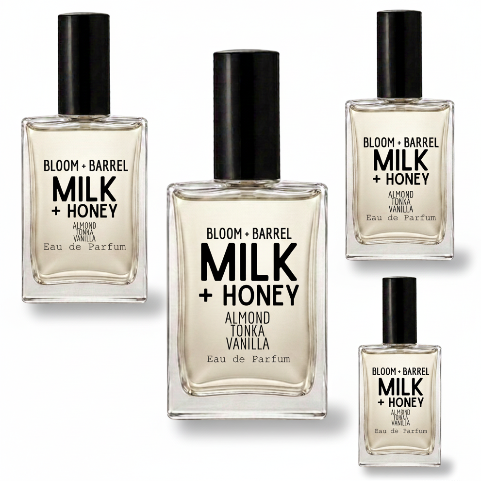Four clear glass perfume bottles with black caps arranged on a white background. The center bottle is largest, with three smaller identical bottles around it.