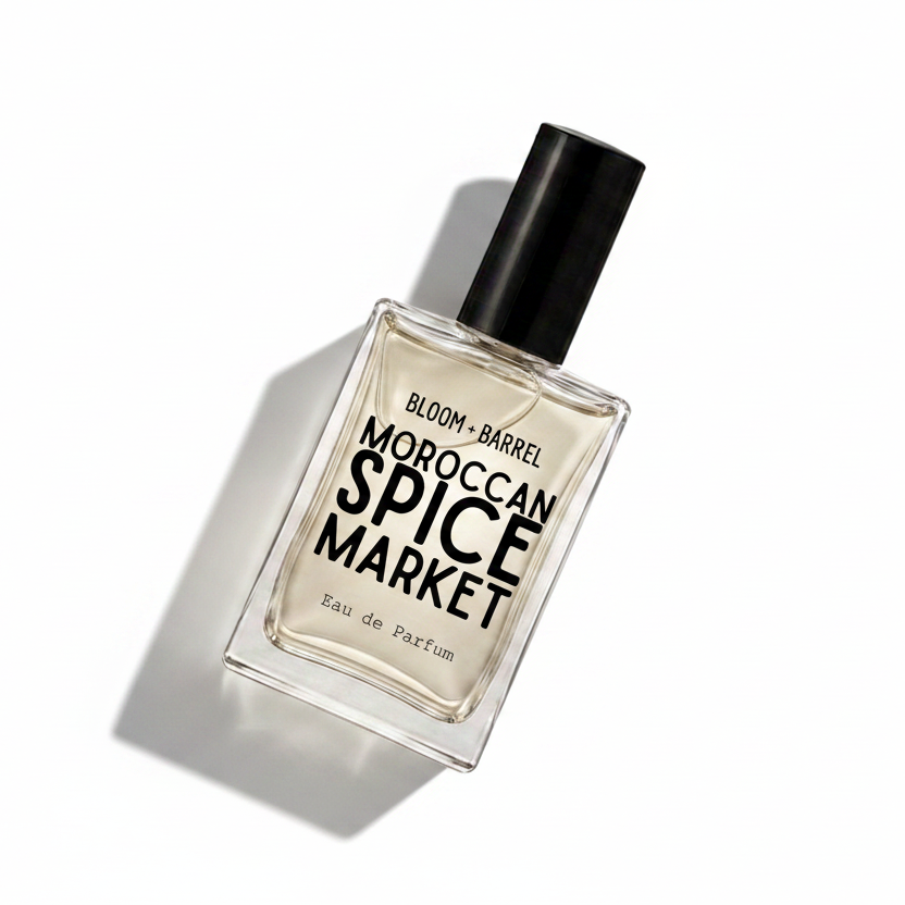 A rectangular glass perfume bottle with a black cap, labeled 'BLOOM • BARREL MOROCCAN SPICE MARKET Eau de Parfum', on a plain white background.