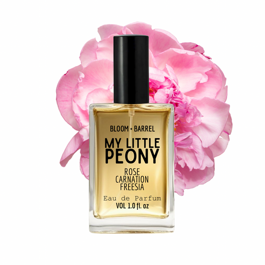 Perfume bottle labeled 'My Little Peony' with pink flowers in the background