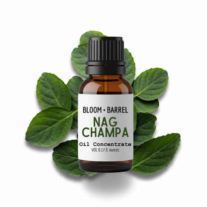 Bottle of Bloom & Barrel Nag Champa oil concentrate surrounded by green leaves on a white background