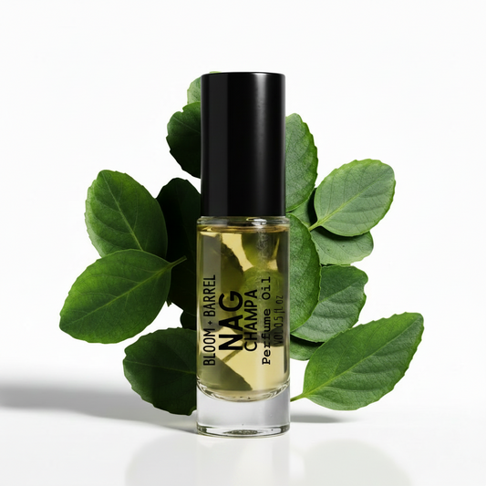 Perfume bottle with green leaves on a white background